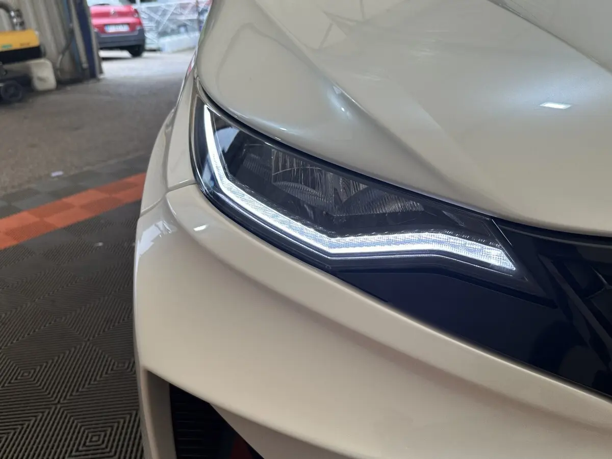 Gros plan sur le phare avant gauche blanc de l'AIXAM AMBITION 0.5 CROSSOVER PREMIUM 2026 avec éclairage LED distinctif.