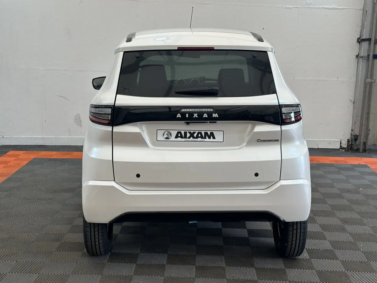 Vue arrière d'une Aixam Ambition 0.5 Crossover Premium blanche, avec logo et feux arrière noirs contrastants.