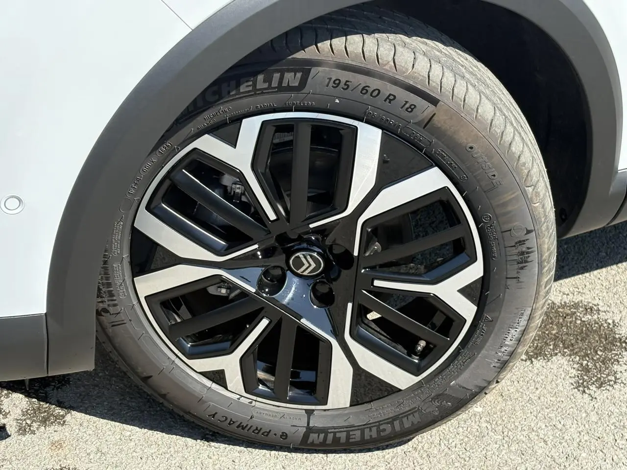 Gros plan sur la jante alliage 18 pouces diamantée noire et argentée du côté avant droit d’une Citroën C4 blanc Okénite.