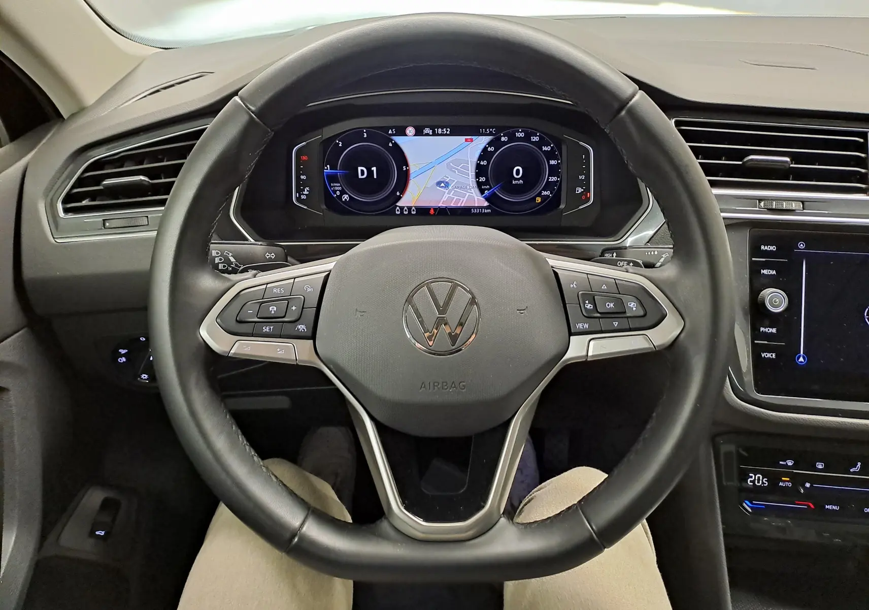 Vue intérieure centrée sur le volant multifonction noir et le tableau de bord numérique du Volkswagen Tiguan 2022.