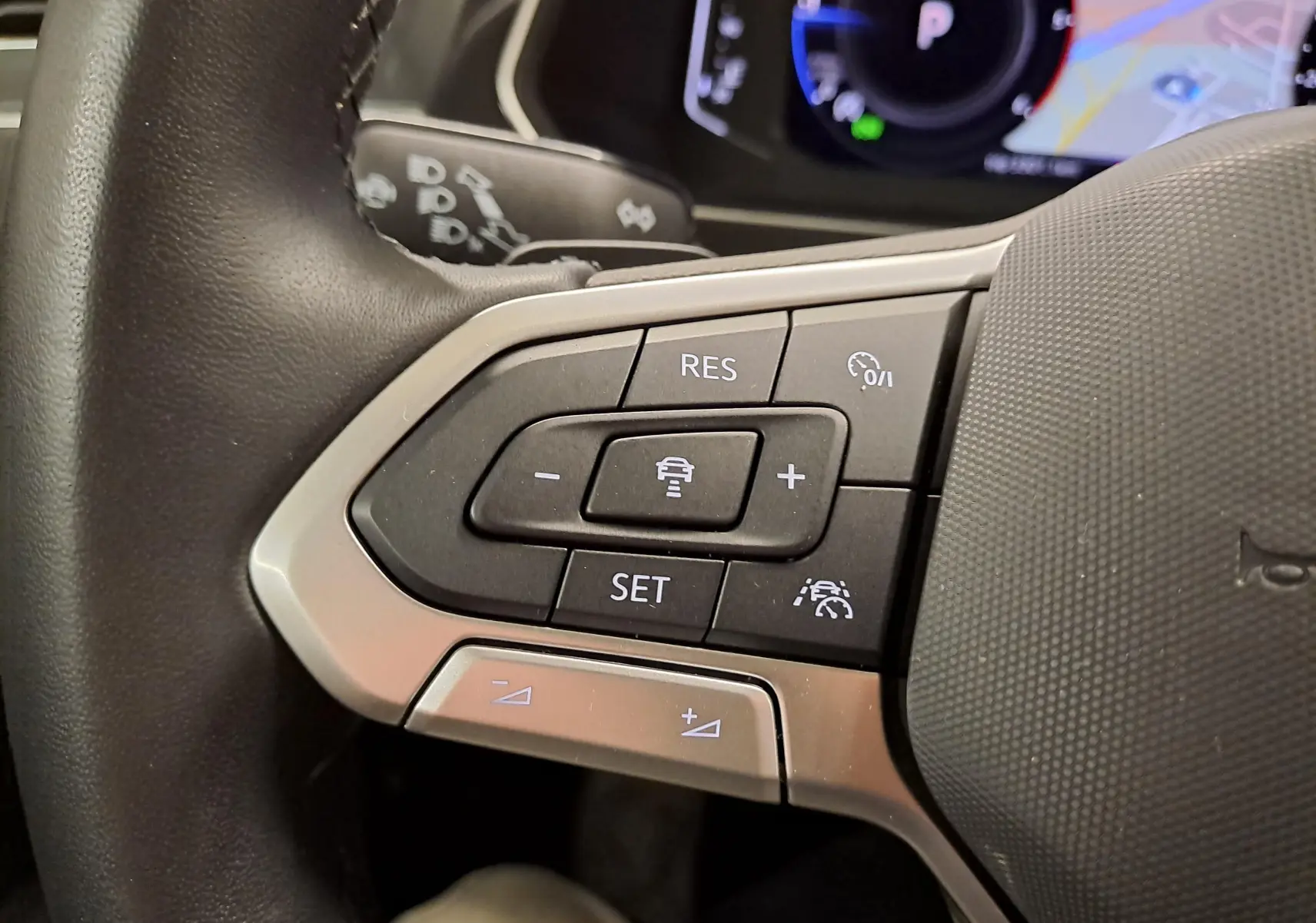 Gros plan sur les commandes du volant du Volkswagen Tiguan 2022, boutons de régulateur de vitesse et assistance au maintien de voie.