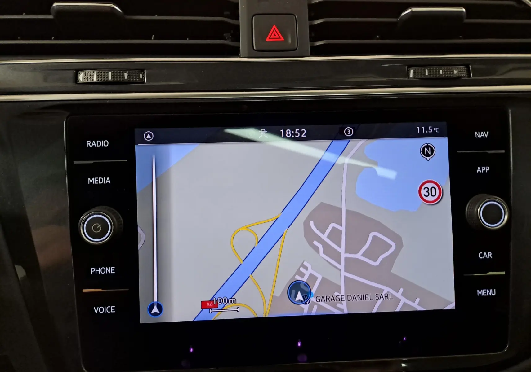 Vue rapprochée de l’écran tactile du Volkswagen Tiguan 2022, affichant la navigation GPS avec interface noire brillante.