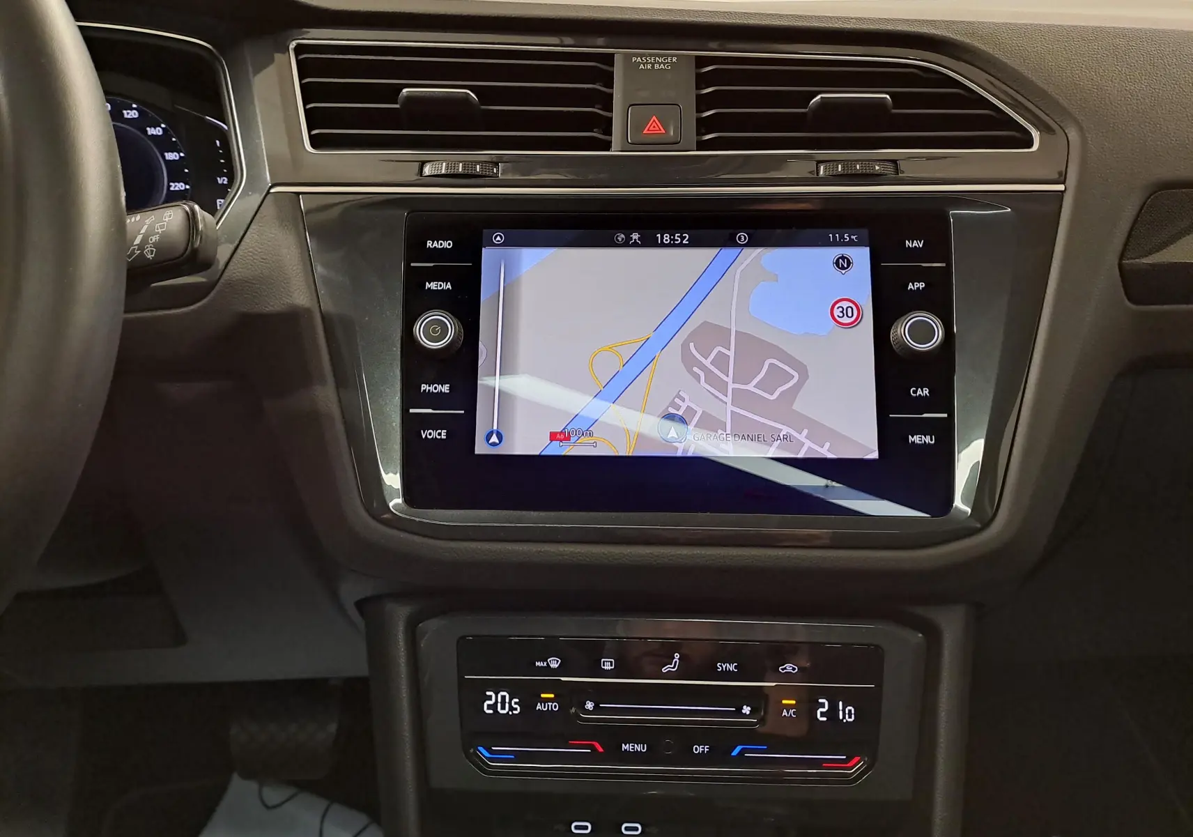 Vue rapprochée du tableau de bord du Volkswagen Tiguan 2022 avec écran tactile de navigation et commandes climatisation.