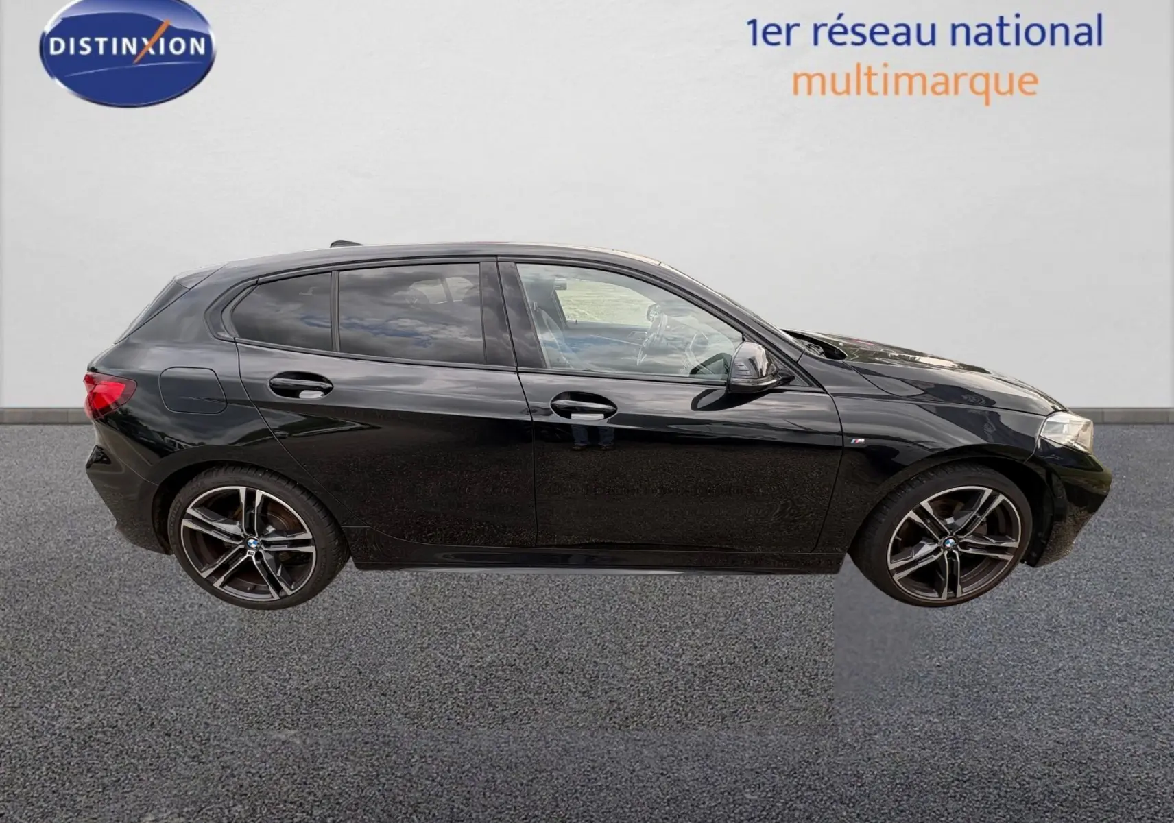 BMW Série 1 116d noire vue de face, mettant en valeur sa calandre noire et ses phares LED distinctifs.