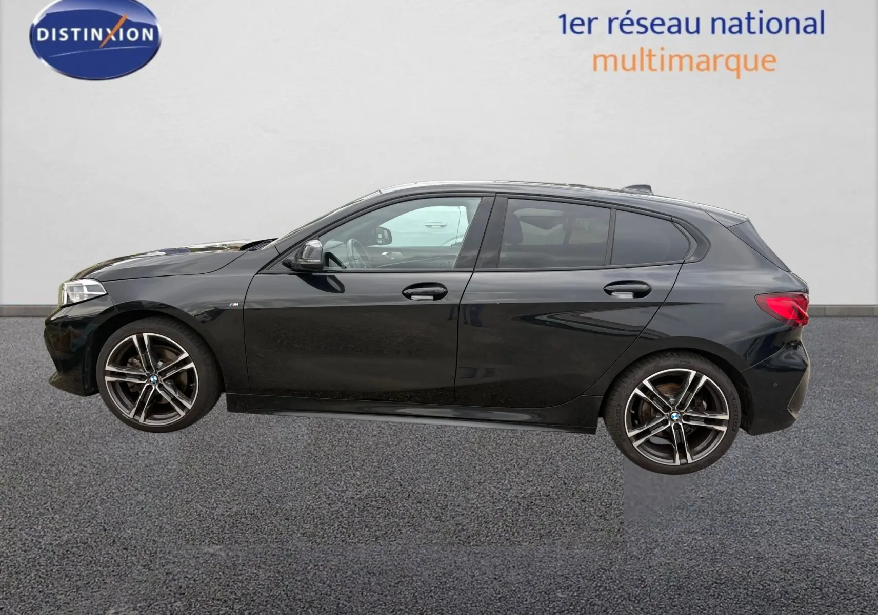 BMW Série 1 116d noire vue en 3/4 avant droit, avec calandre noire et jantes M Sport distinctives.