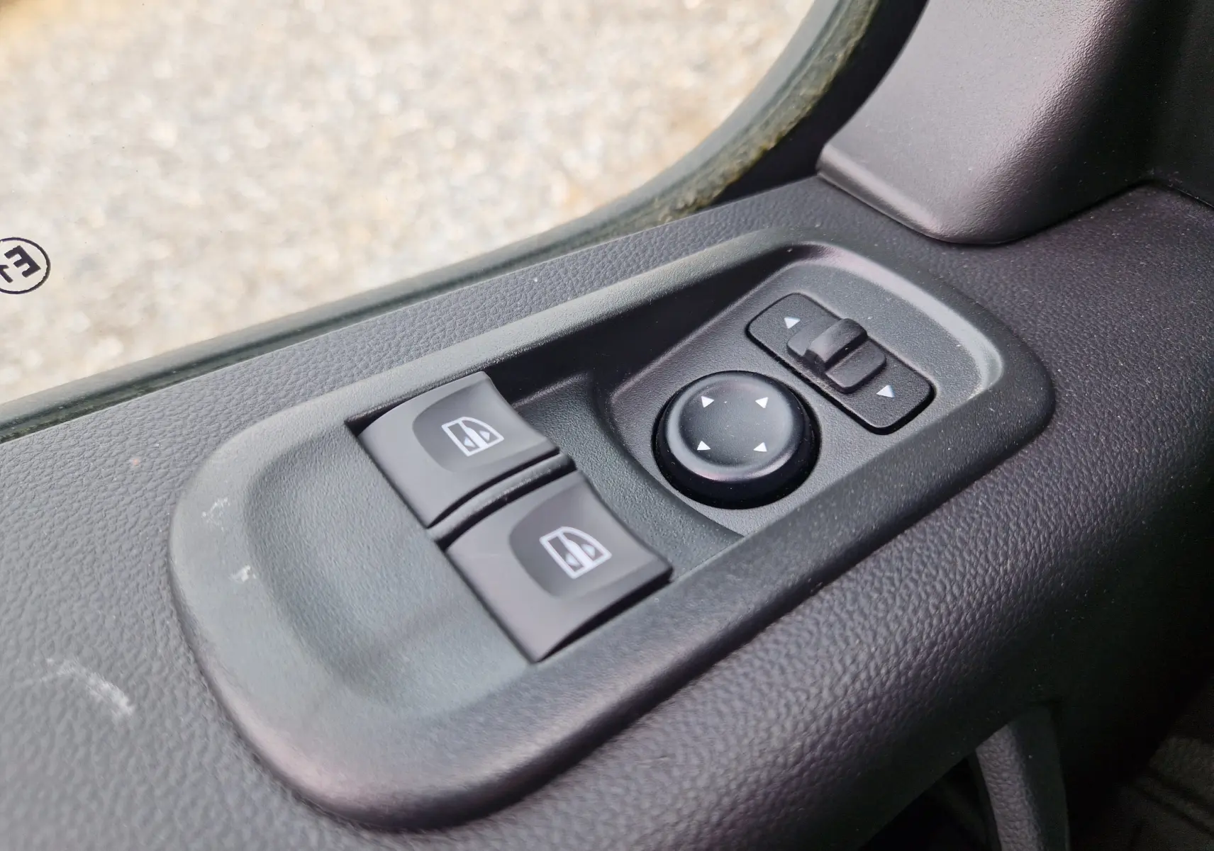 Gros plan sur les commandes électriques des vitres et des rétroviseurs côté conducteur du Renault Master blanc TPMR 2020.