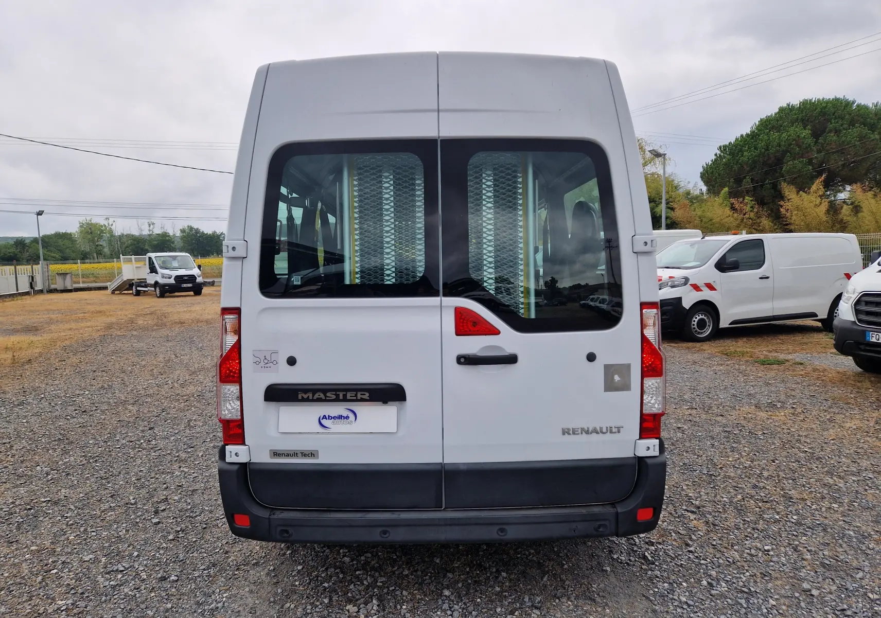 Vue arrière d’un Renault Master blanc 2020 avec portes vitrées et rampe d’accès pour fauteuil roulant.