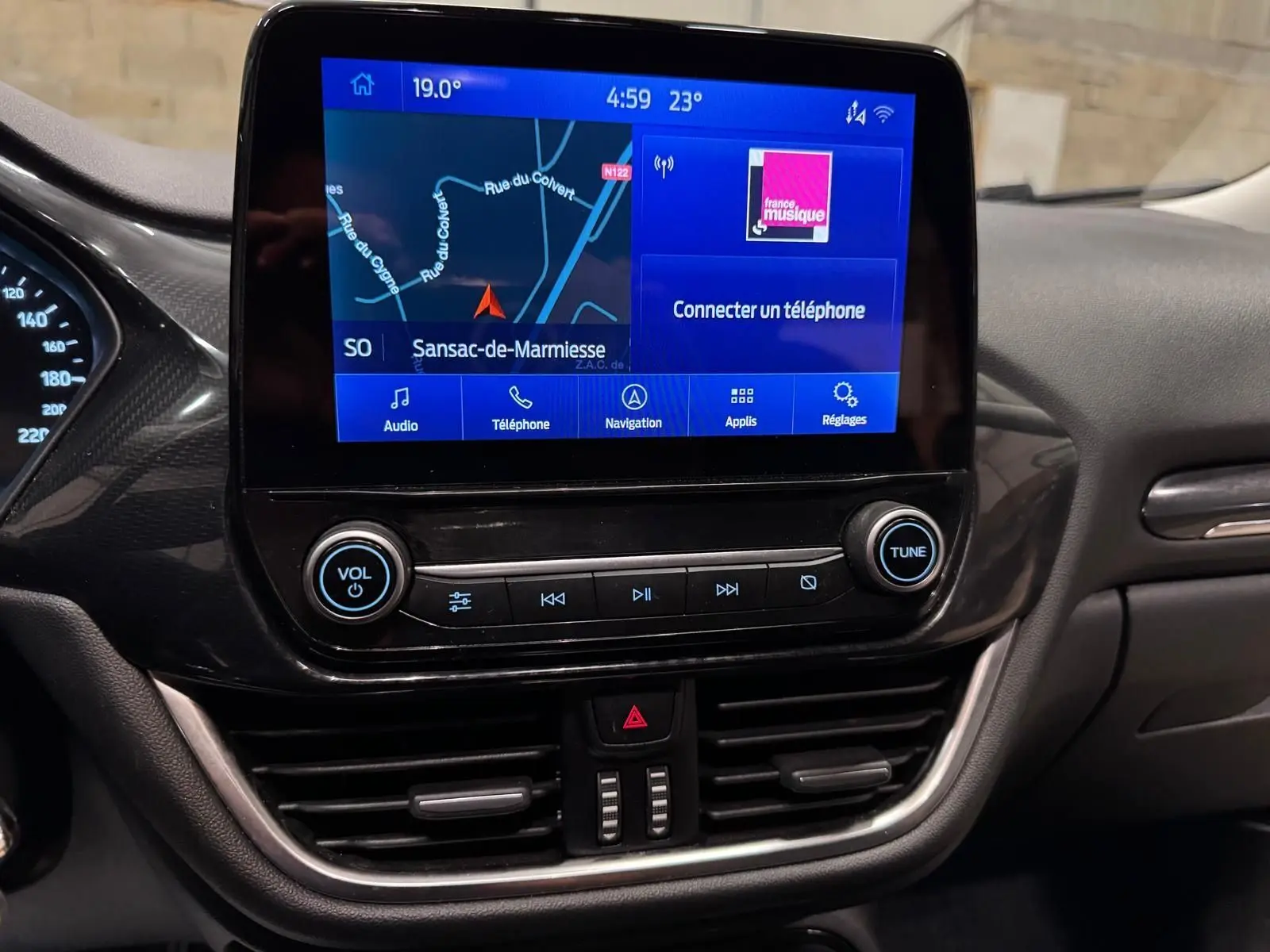 Écran tactile central du tableau de bord du Ford Puma gris Solar 2023, affichant navigation et options multimédia.
