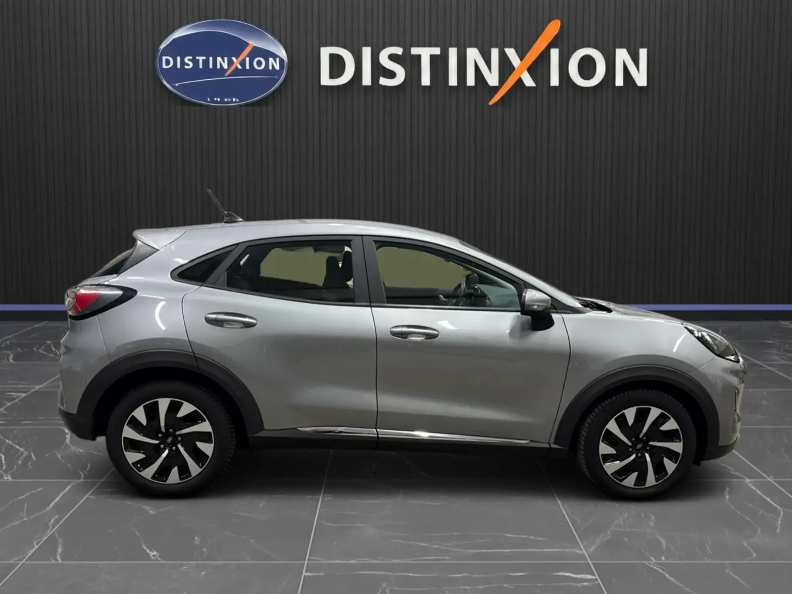 Ford Puma gris solar vu de profil côté gauche, soulignant ses jantes bicolores et lignes fluides.