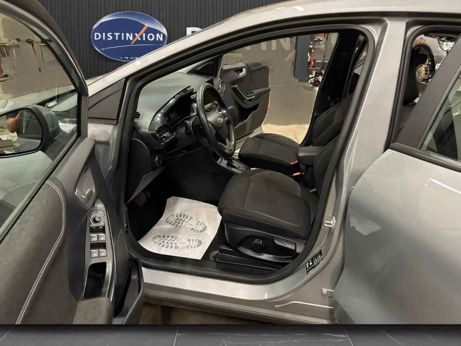 Vue intérieure côté conducteur du Ford Puma gris Solar 2023, montrant sièges noirs et tableau de bord moderne.