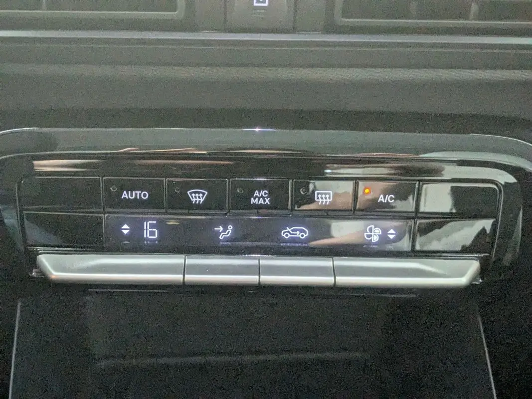 Gros plan sur la commande de climatisation automatique du Citroën E-C3 Aircross noir, affichant 16°C et fonction A/C activée.