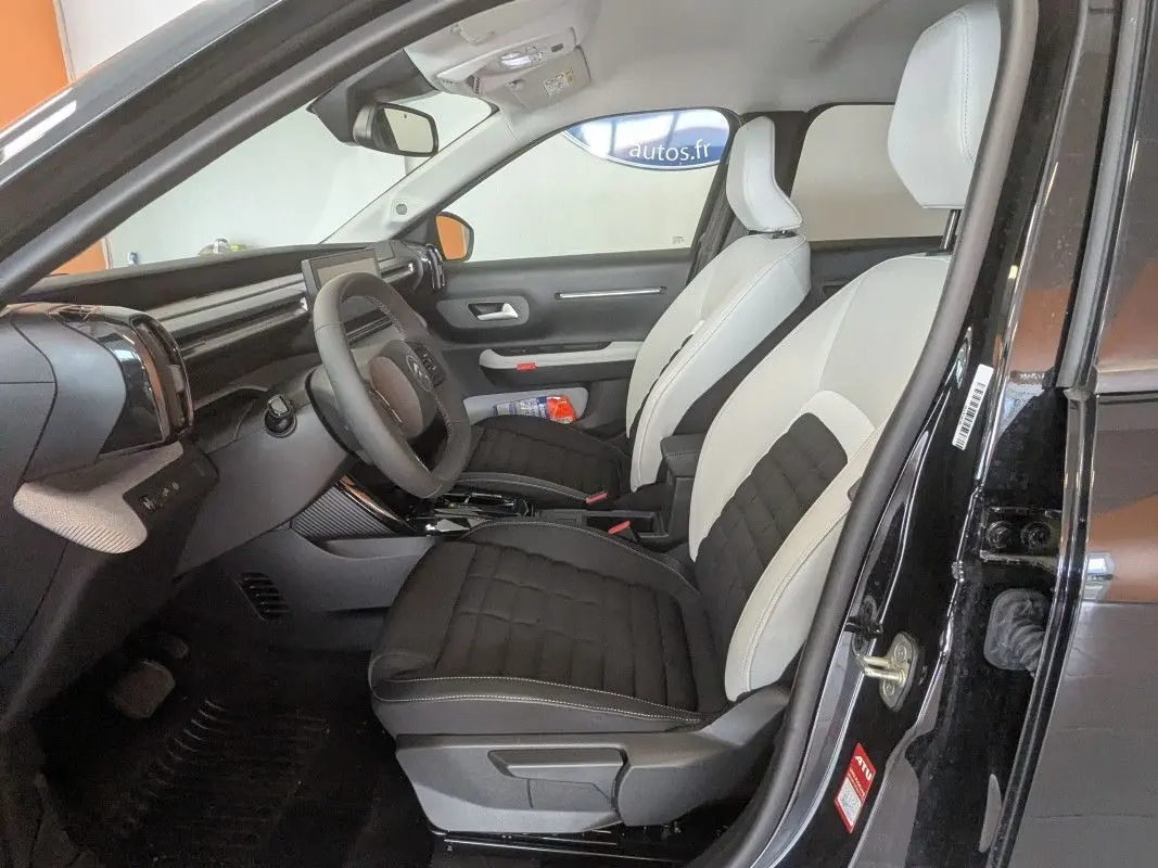 Intérieur avant droit du Citroën E-C3 Aircross 2025 noir, sellerie bicolore TEP/tissu avec tableau de bord moderne.