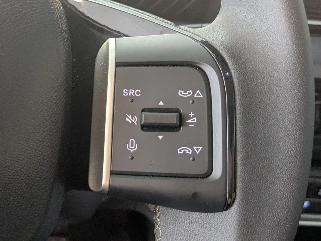 Gros plan sur les commandes de volume et téléphone au volant du Citroën E-C3 Aircross noir 2025.