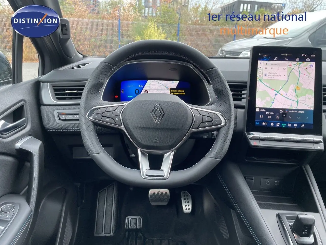 Vue intérieure centrée sur le volant Renault Symbioz gris, avec tableau de bord numérique et écran tactile de navigation.