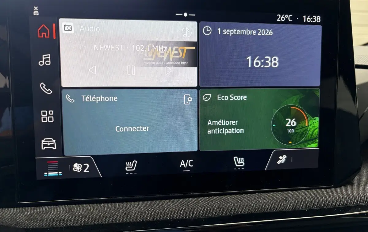 Écran tactile central de la Renault Clio Evolution+ hybride rouge 2025 affichant radio, téléphone et Eco Score.