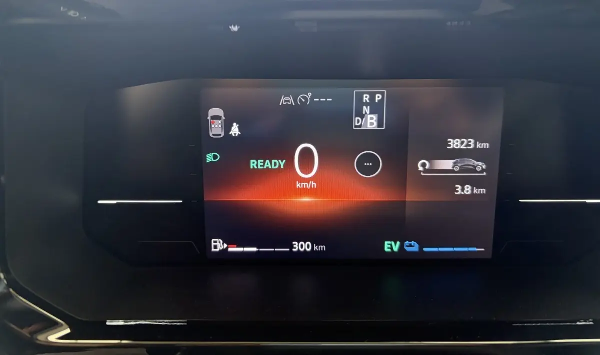 Affichage numérique du tableau de bord de la Renault Clio 2025 rouge, montrant la vitesse à 0 km/h et l'autonomie hybride.