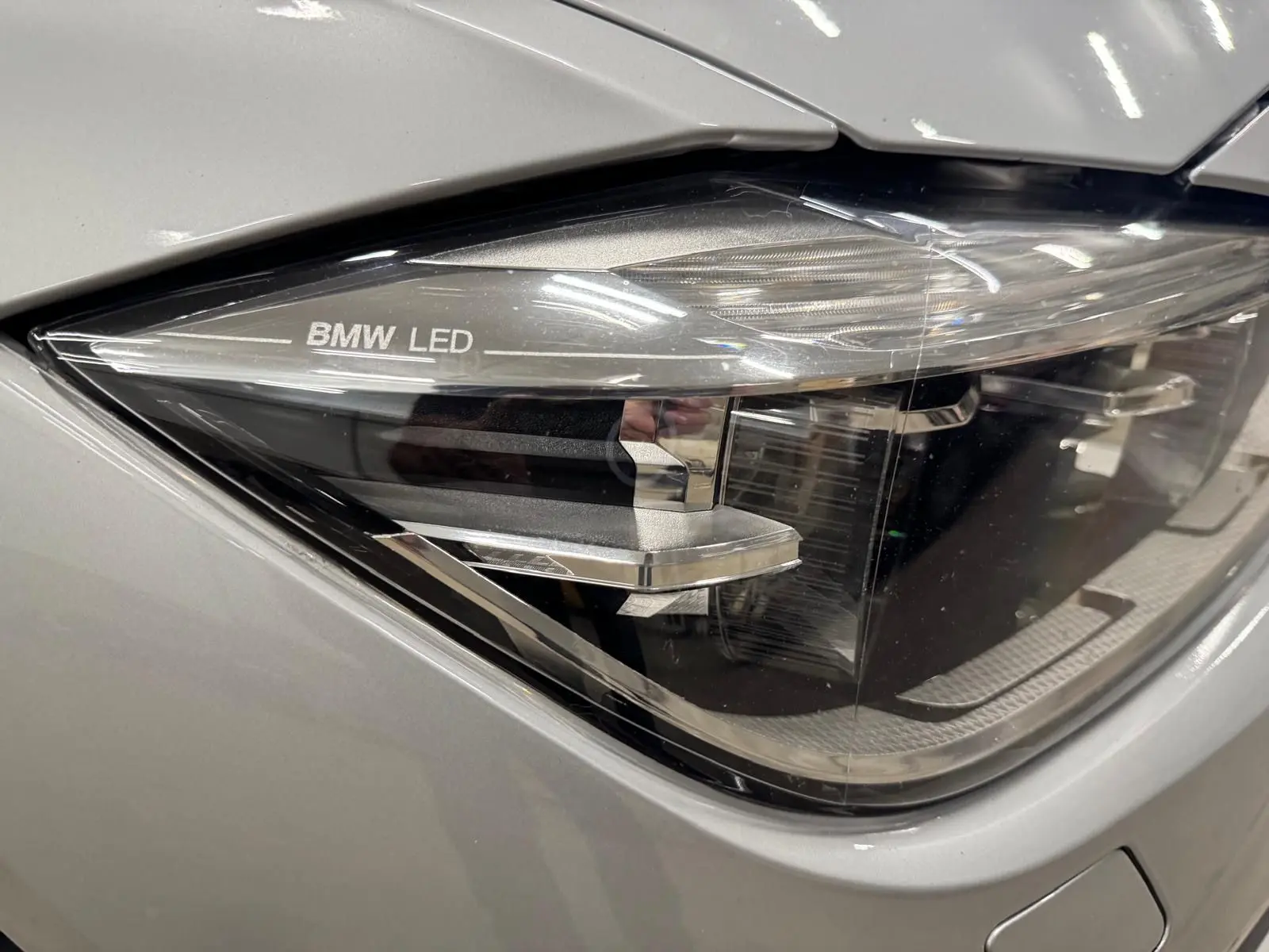 Gros plan sur le phare avant droit LED d’une BMW Série 3 Touring F31 gris aluminium, mettant en valeur le marquage BMW LED.
