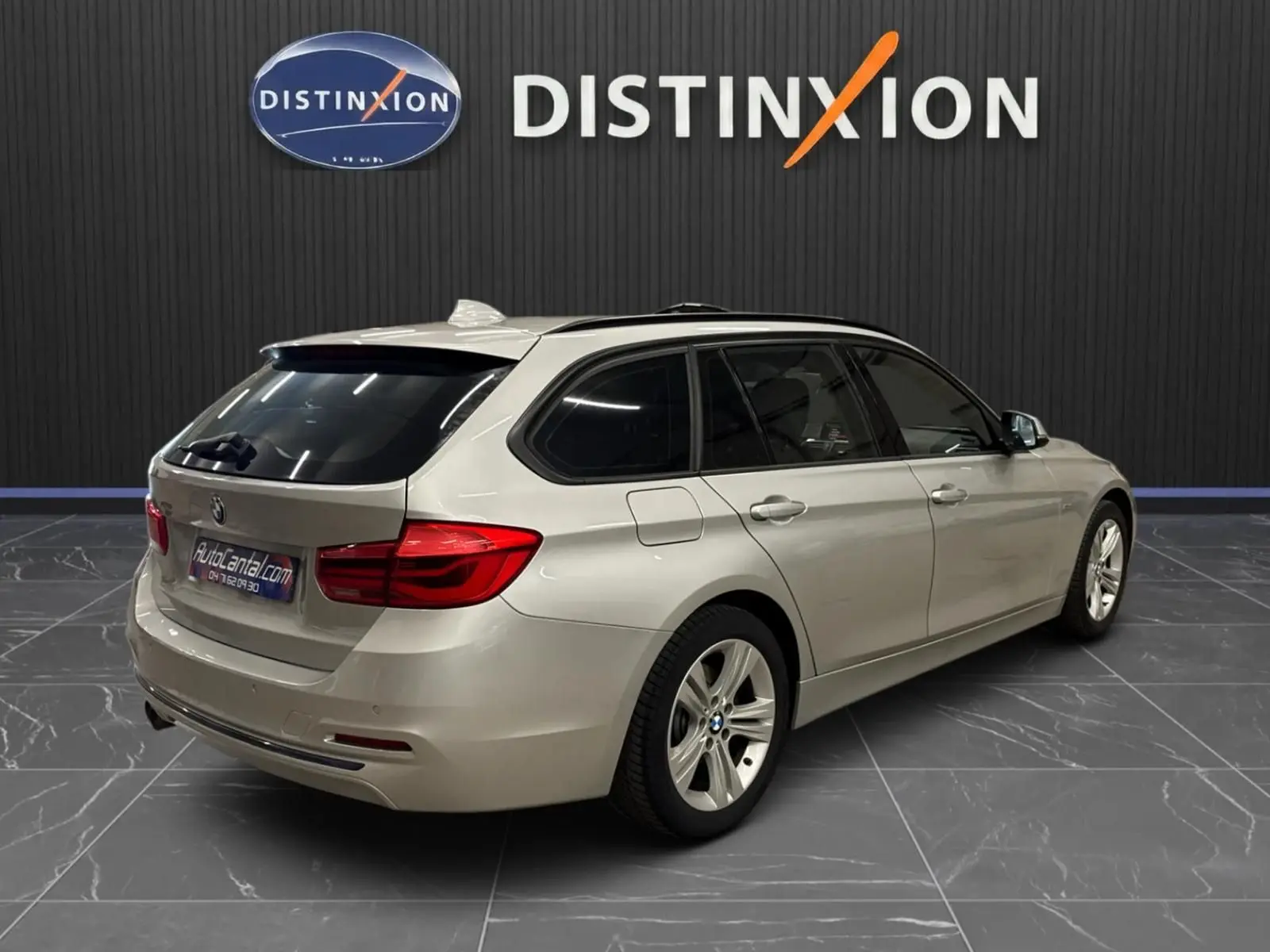 BMW Série 3 Touring gris aluminium vue 3/4 arrière droit, avec attelage électrique et jantes 17 pouces.