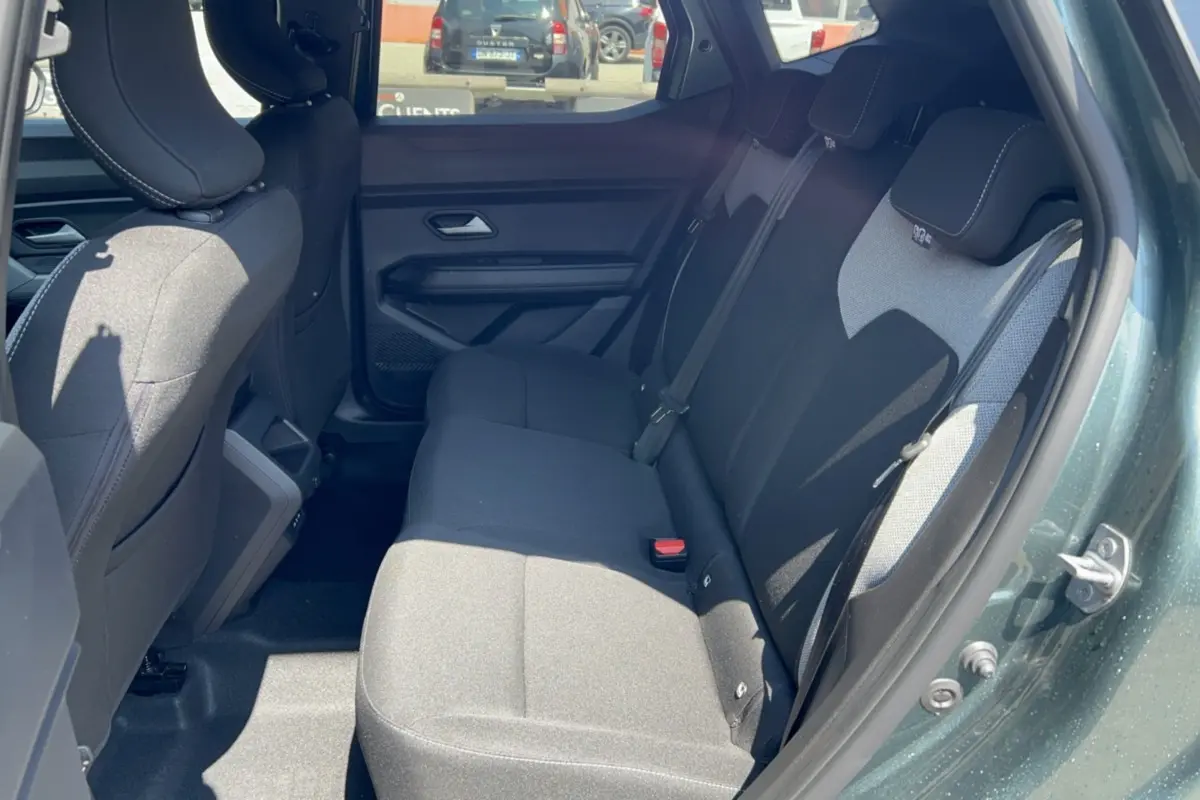 Vue intérieure côté droit montrant la banquette arrière noire du Dacia Duster Hybrid-G 150 4x4 en vert cèdre.