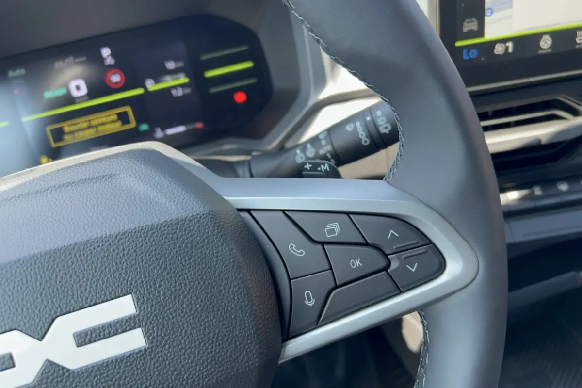 Gros plan sur le volant cuir à commandes multifonctions côté droit du Dacia Duster Hybrid-G 150 4x4 2026.