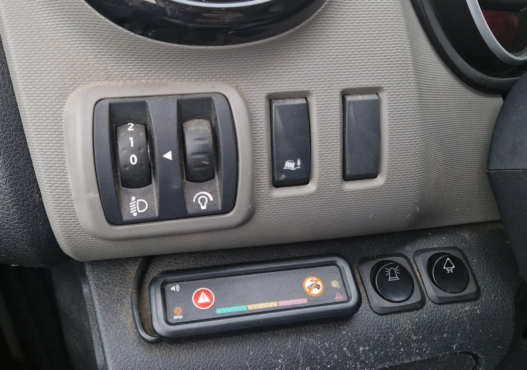 Gros plan sur les commandes grises et noires du tableau de bord du Renault Trafic Fourgon blanc, version 2019.