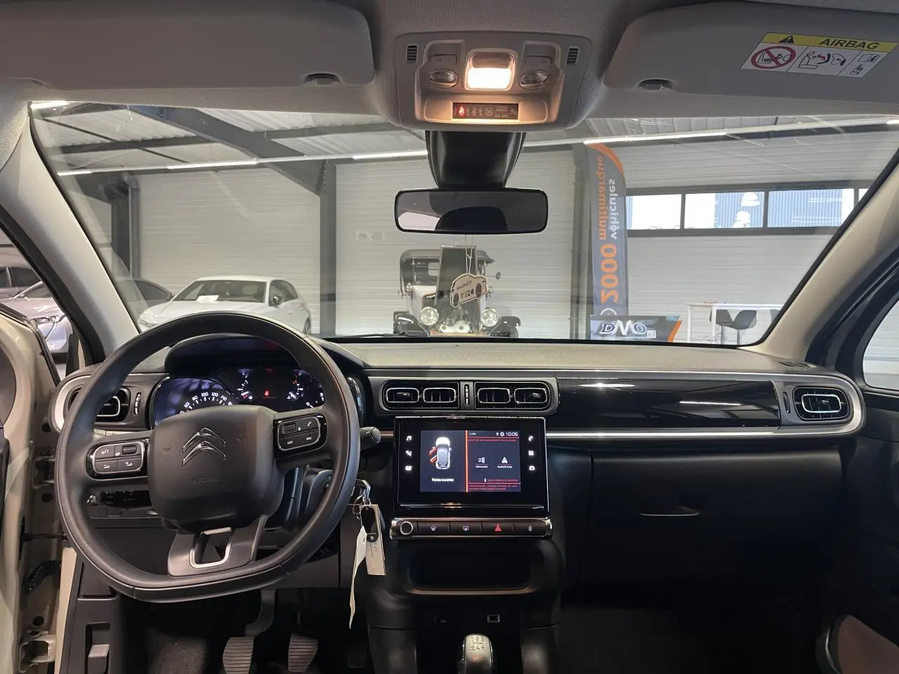 Intérieur avant de la Citroën C3 beige clair 2024, tableau de bord avec écran tactile et volant multifonction.