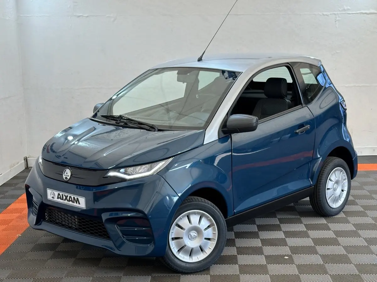 Vue 3/4 avant droite d'une Aixam Ambition 0.5 City Pack bleu 2026 avec rétroviseur caméra côté gauche.
