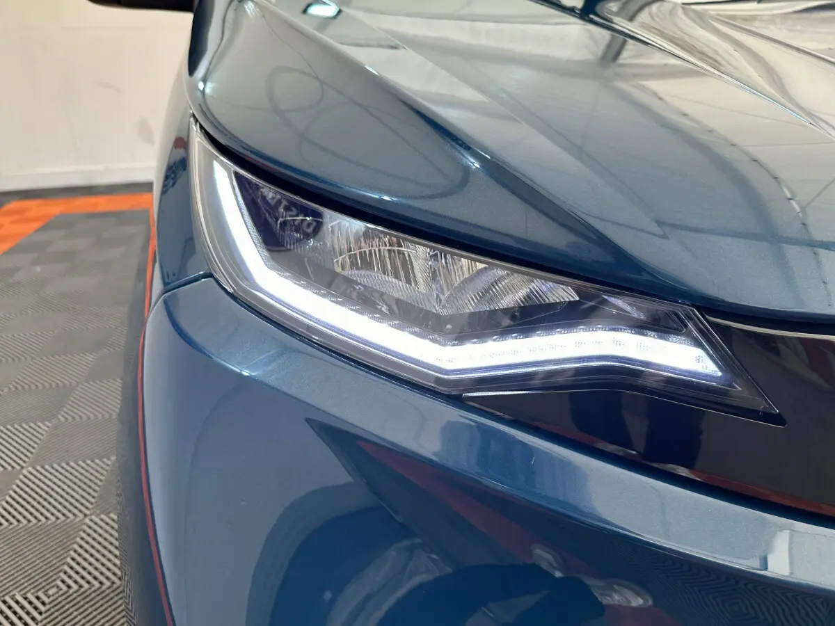 Gros plan sur le phare avant gauche d’une Aixam Ambition 0.5 City Pack bleu 2026 avec éclairage LED distinctif.