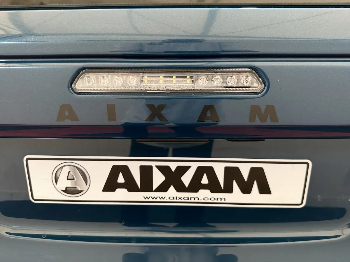 Gros plan sur l'arrière bleu d'une Aixam Ambition 0.5 City Pack avec feu stop et logo AIXAM visible.