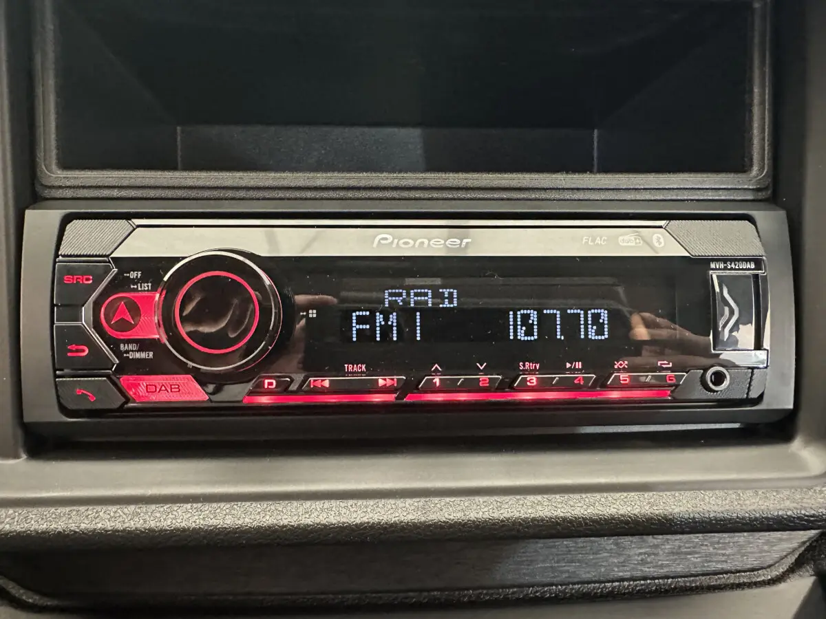 Vue rapprochée de la radio Pioneer intégrée dans le tableau de bord de l'Aixam Ambition 0.5 City Pack bleu.