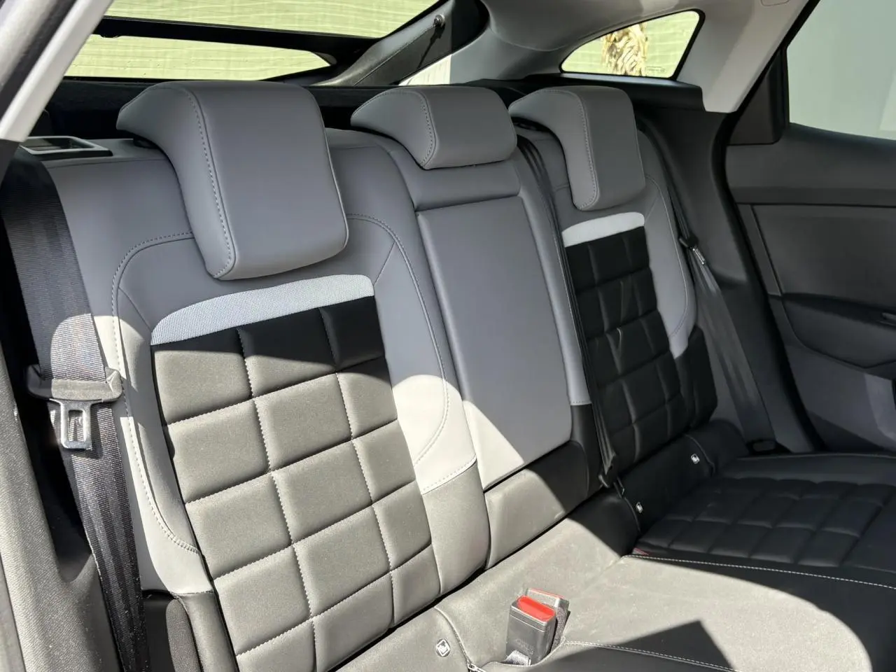 Vue intérieure arrière des sièges gris clair et noir en tissu enduit du Citroën C4 Hybrid 2025.