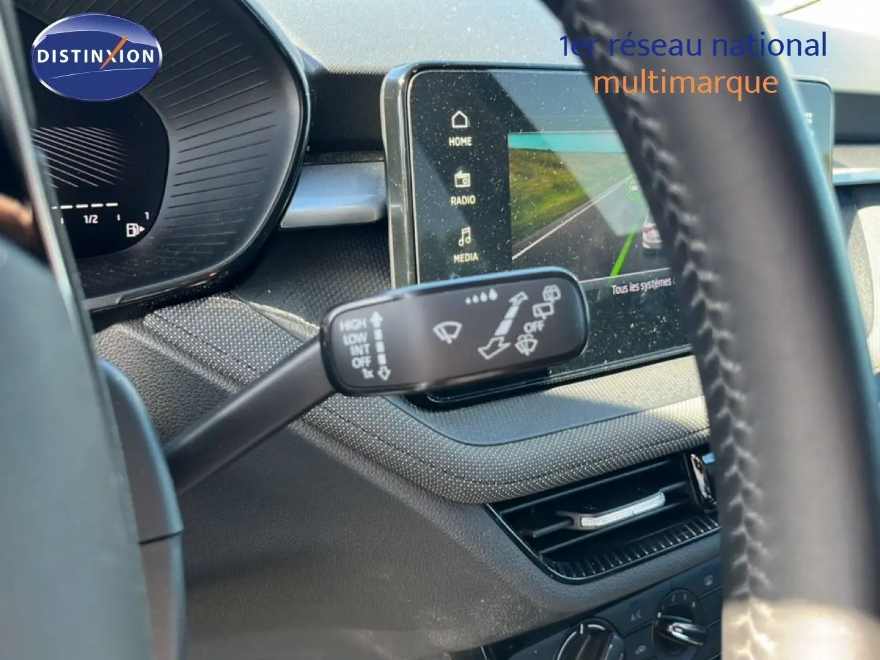 Vue intérieure rapprochée du combiné d'instruments et du commodo d'essuie-glace d'une Skoda Fabia noire.