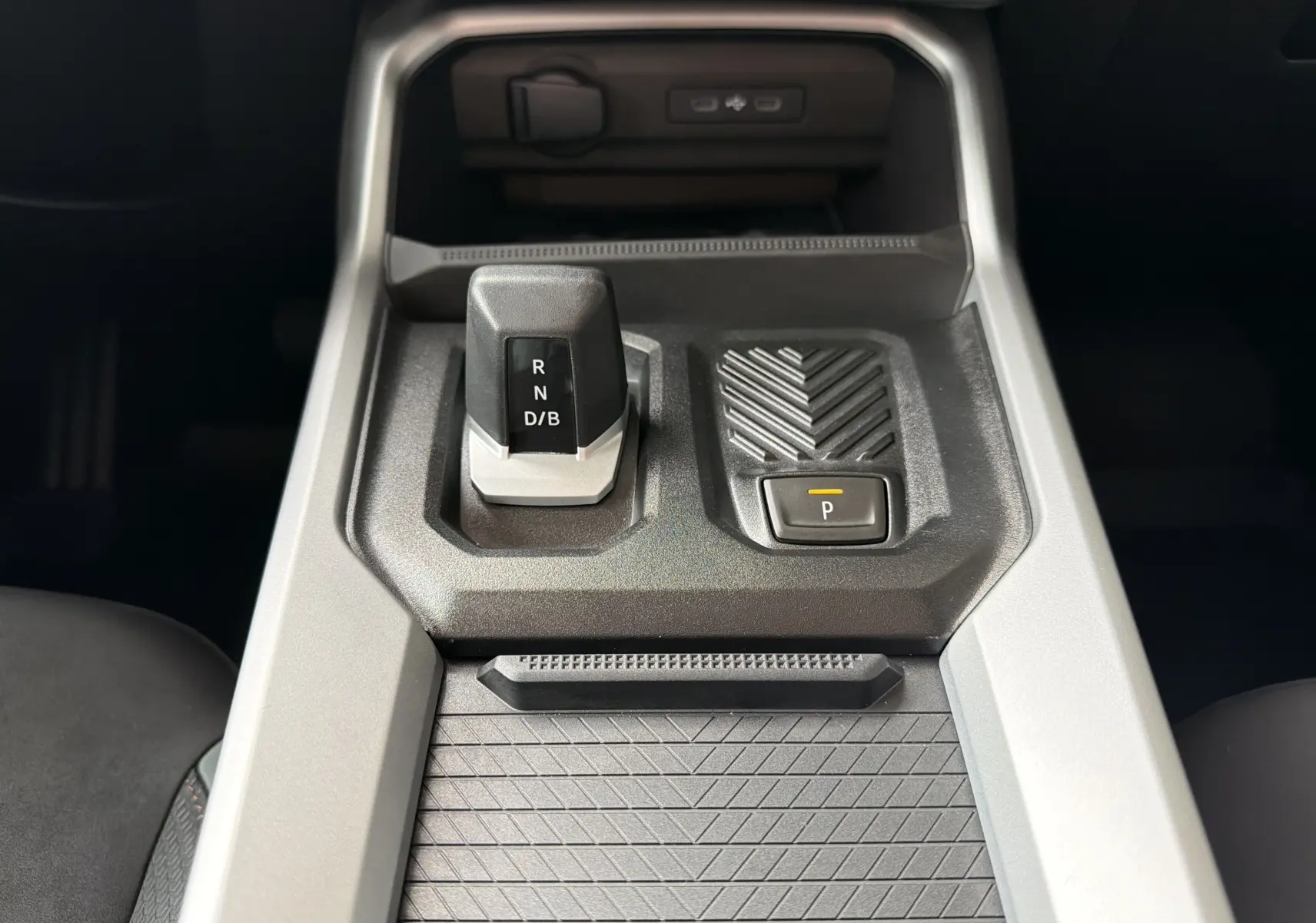 Gros plan sur la console centrale du Dacia Bigster Hybrid 155 Extreme, avec levier de vitesse automatique et bouton parking.