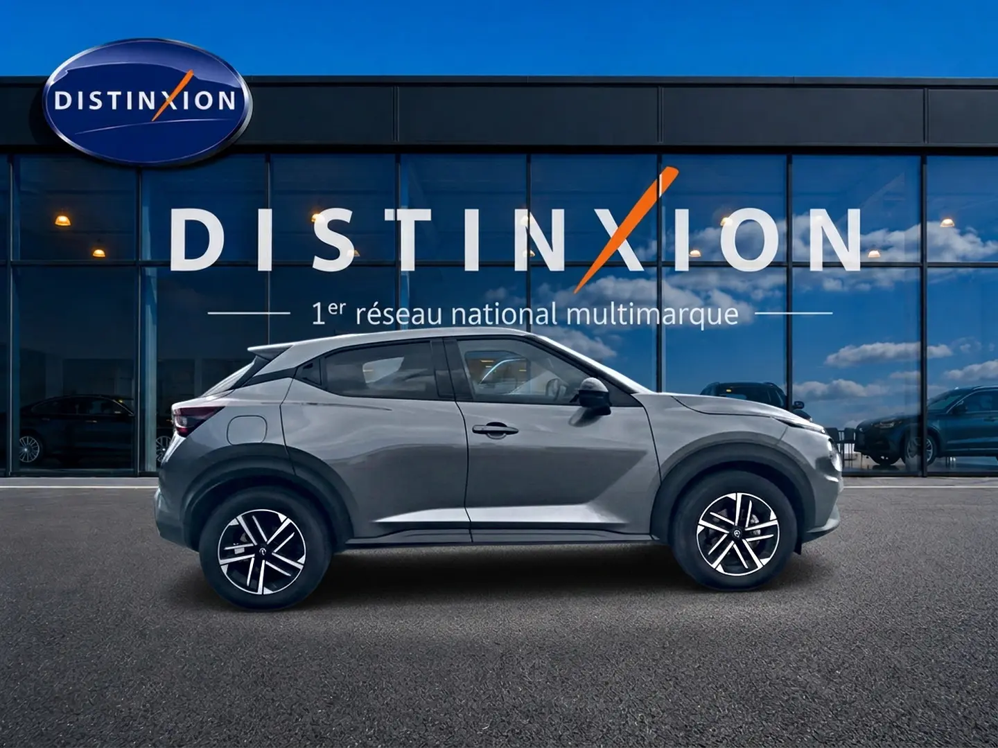 Vue de profil côté gauche d'un Nissan Juke gris 2025 avec jantes alliage et boucliers ton carrosserie.