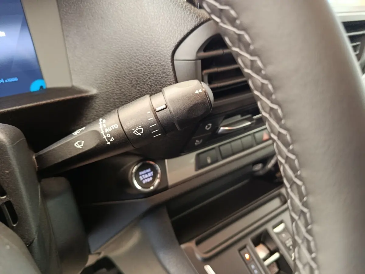 Gros plan sur la commande d’essuie-glace et le bouton start/stop du tableau de bord du Peugeot Expert Fourgon noir.