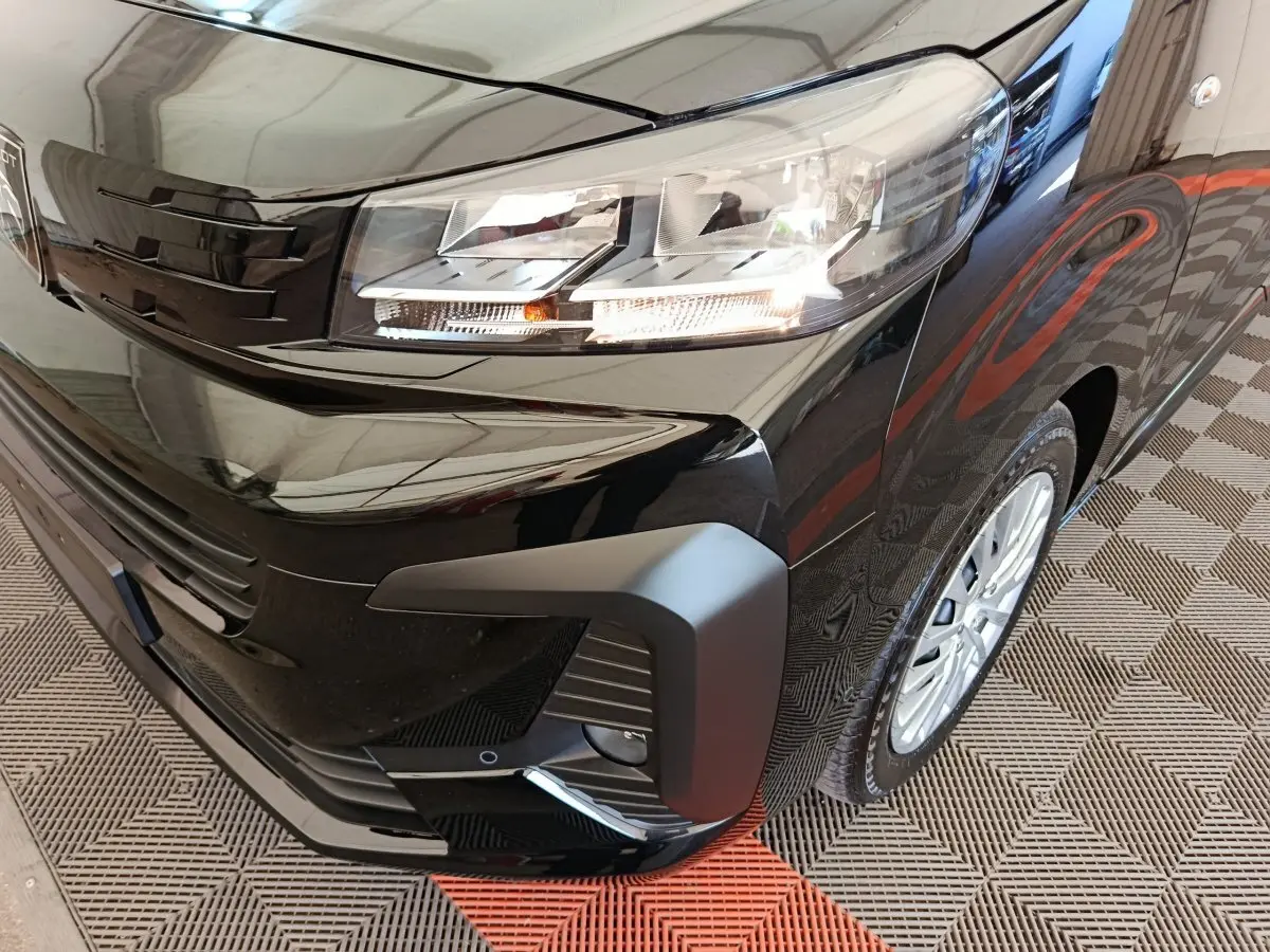 Gros plan sur l’avant droit du Peugeot Expert Fourgon XL noir, mettant en valeur le phare et la calandre moderne.