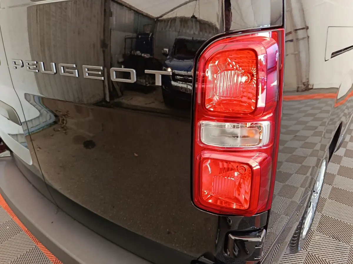 Gros plan sur le feu arrière droit d’un Peugeot Expert Fourgon XL noir, avec logo Peugeot visible sur la porte arrière.