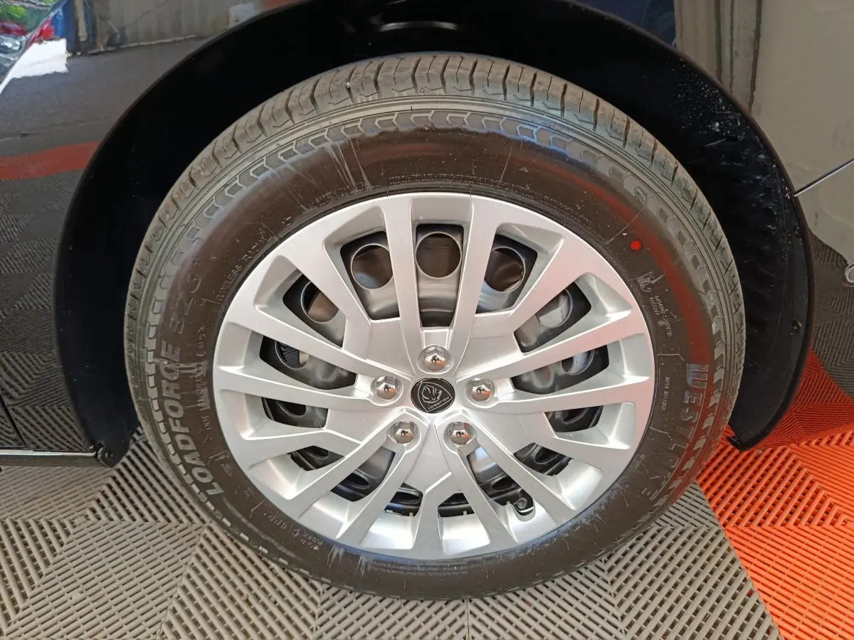 Gros plan sur la roue avant droite noire du Peugeot Expert Fourgon XL Diesel 180 ch avec jante argentée multi-branches.