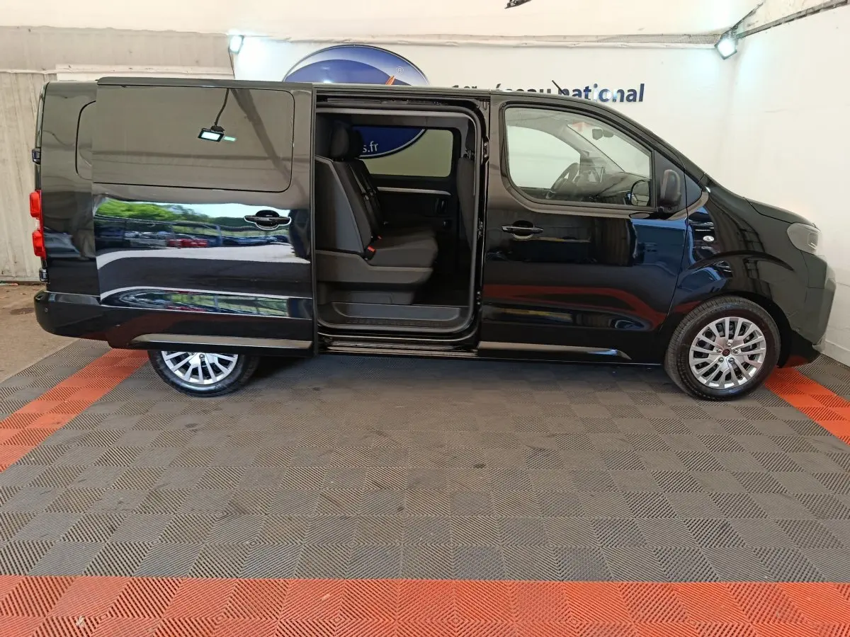 Vue latérale gauche du Peugeot Expert Fourgon XL noir avec porte coulissante ouverte montrant les sièges avant.
