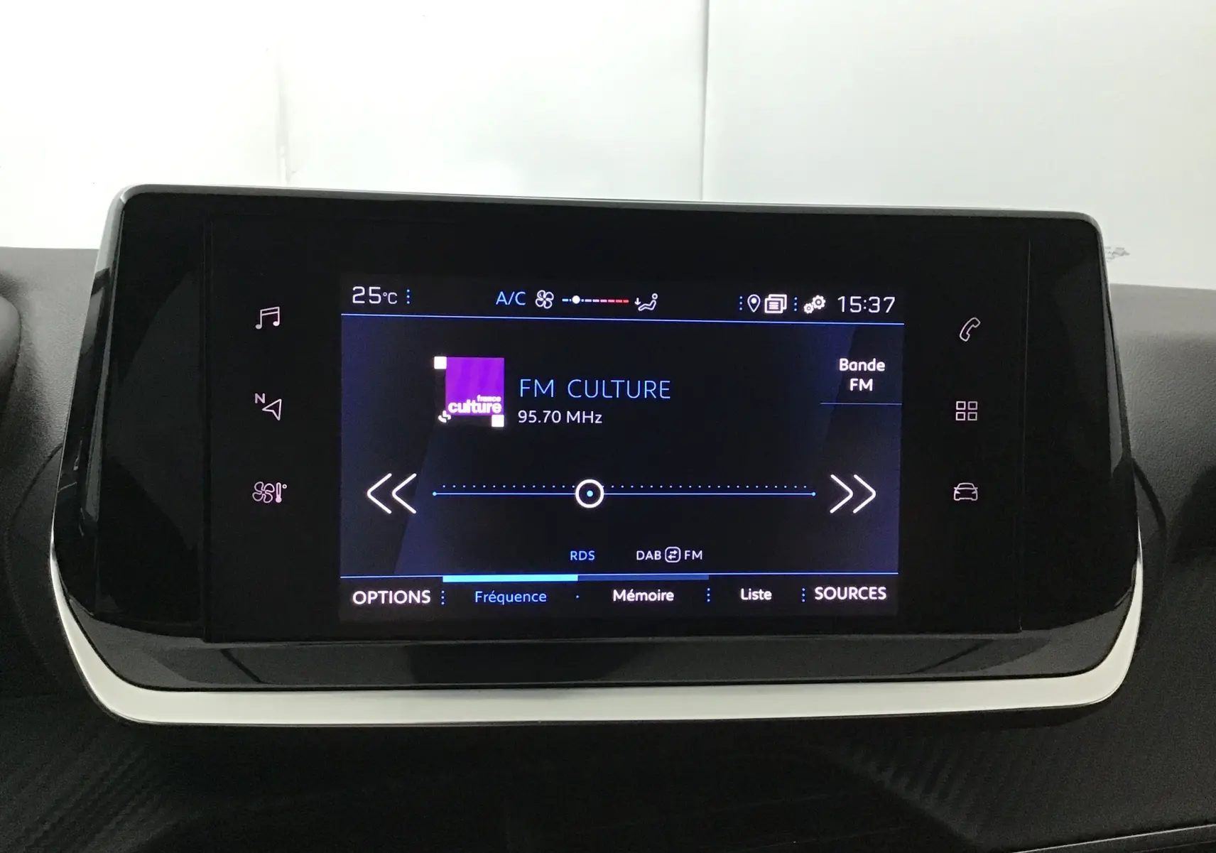 Écran tactile central du tableau de bord de la Peugeot 208 noire, affichant la radio FM Culture à 95,7 MHz.