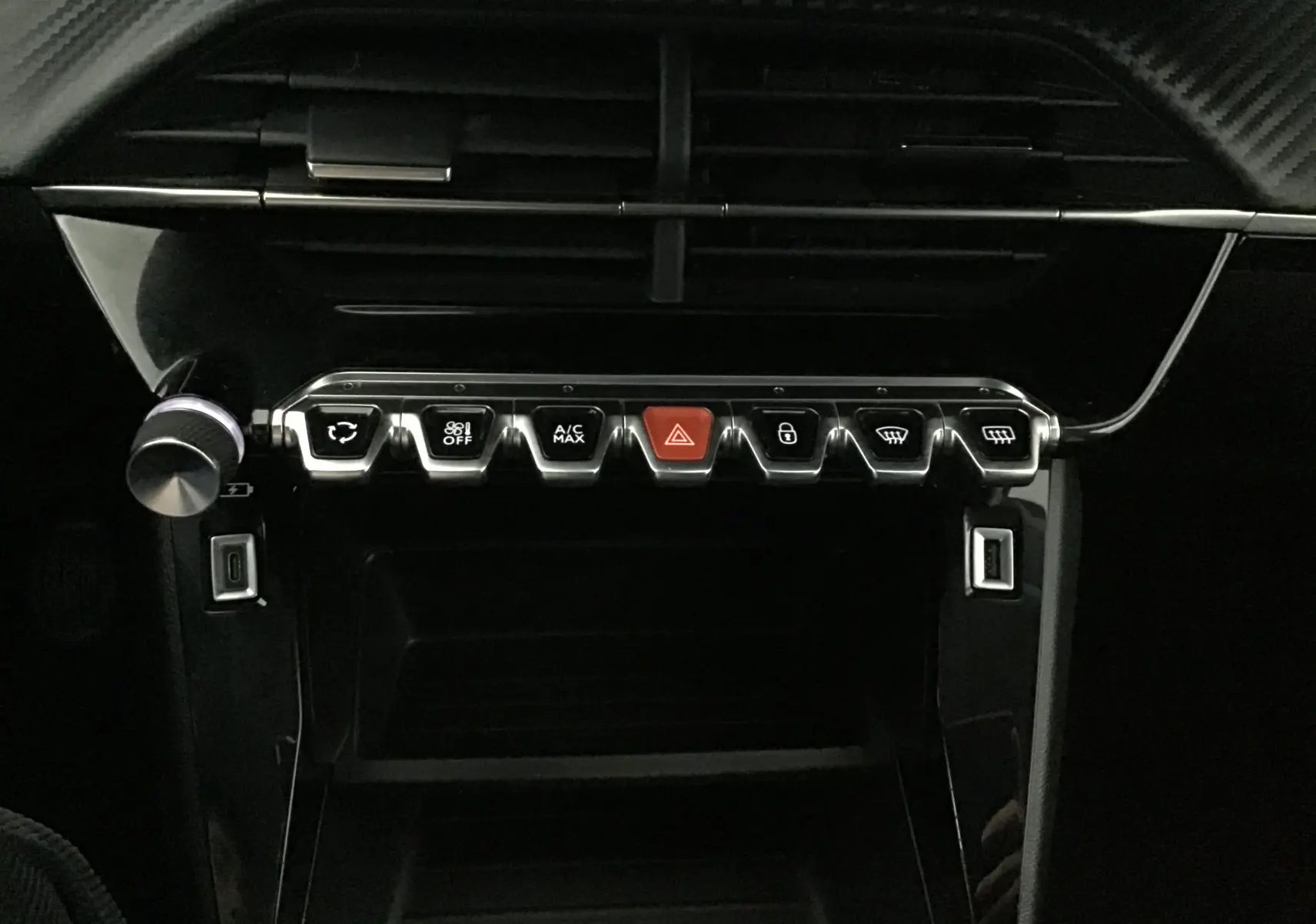 Tableau de bord noir du Peugeot 208 1.2 PureTech 2022 montrant les boutons de commande climatisation et sécurité.