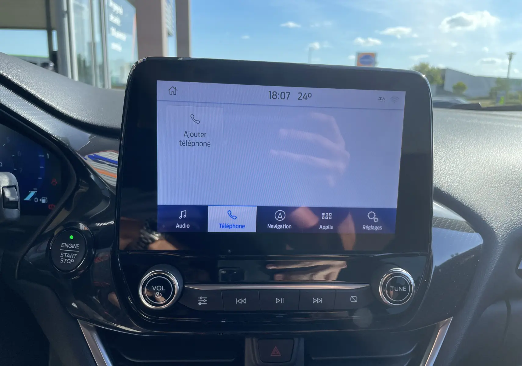 Écran tactile central du Ford Puma 2021 rouge, affichant le menu téléphone avec commandes audio et bouton start/stop visibles.