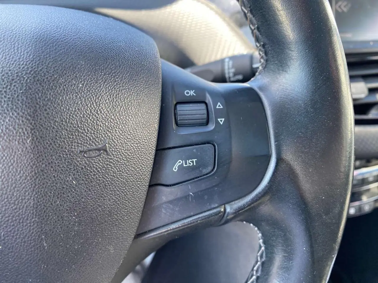 Gros plan sur le volant cuir noir du Peugeot 2008 2019 avec commandes multifonctions côté gauche.