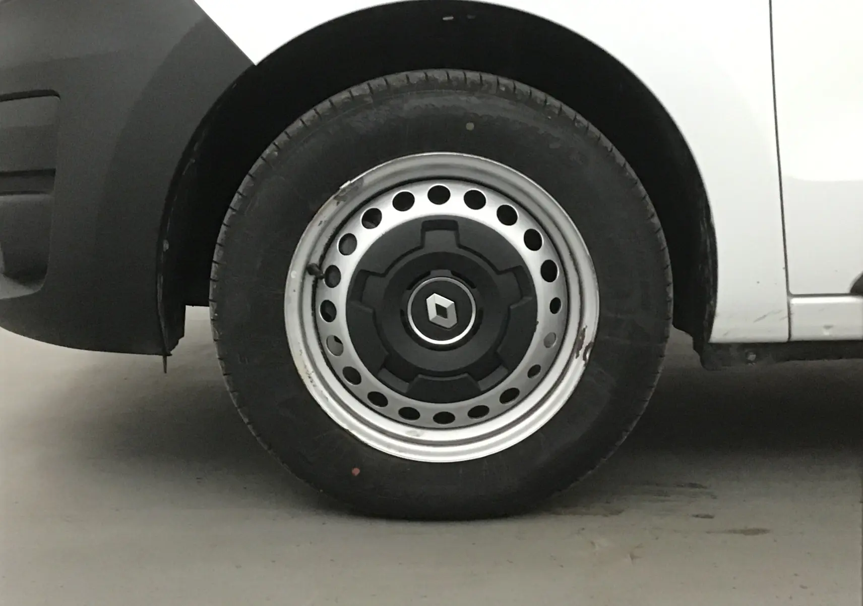 Gros plan sur la roue avant gauche d'un Renault Express Van blanc avec jante acier et logo Renault central.