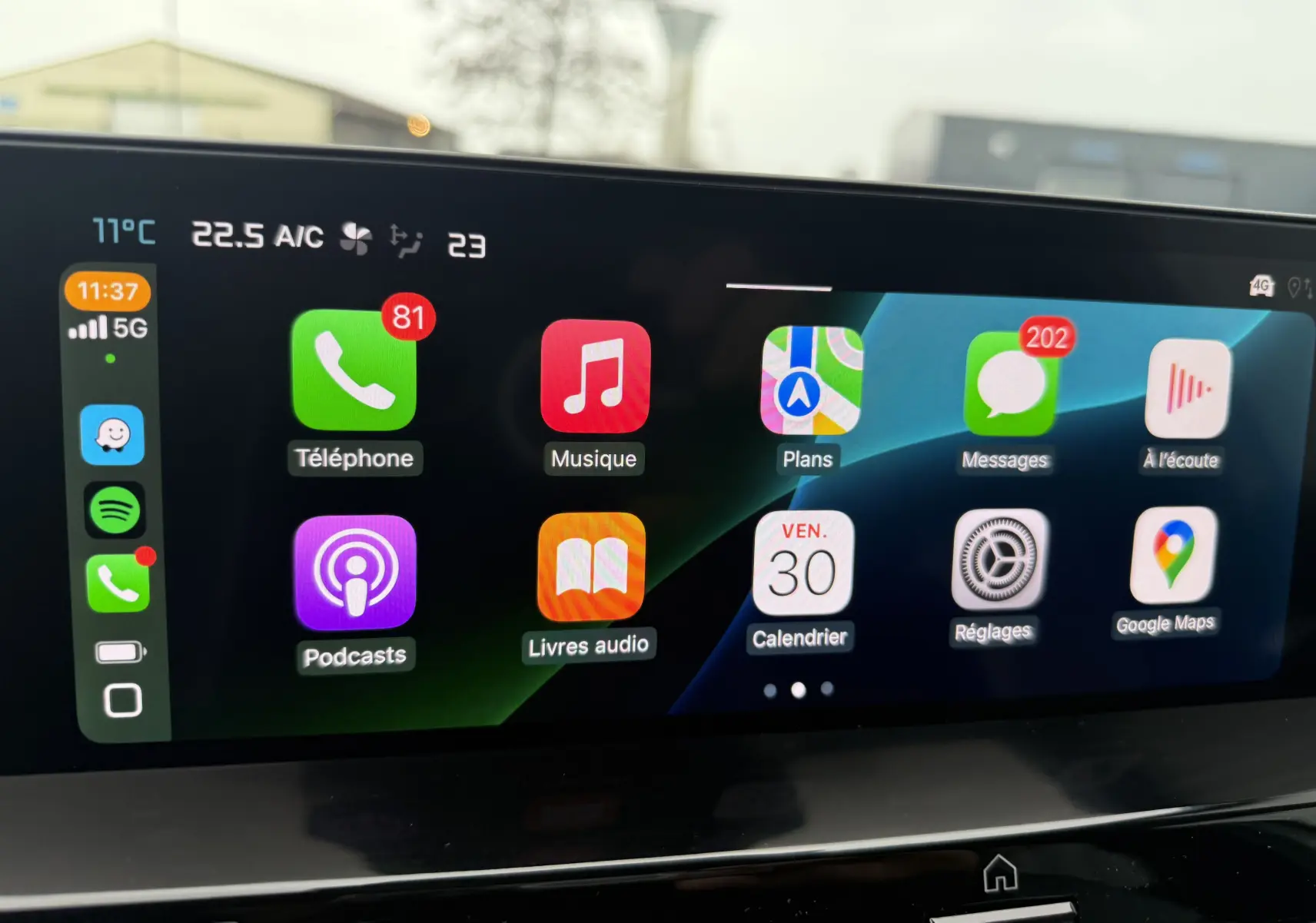 Écran tactile intérieur de Citroën C4 Hybrid 145 blanc, affichant les applications connectées en plein jour.