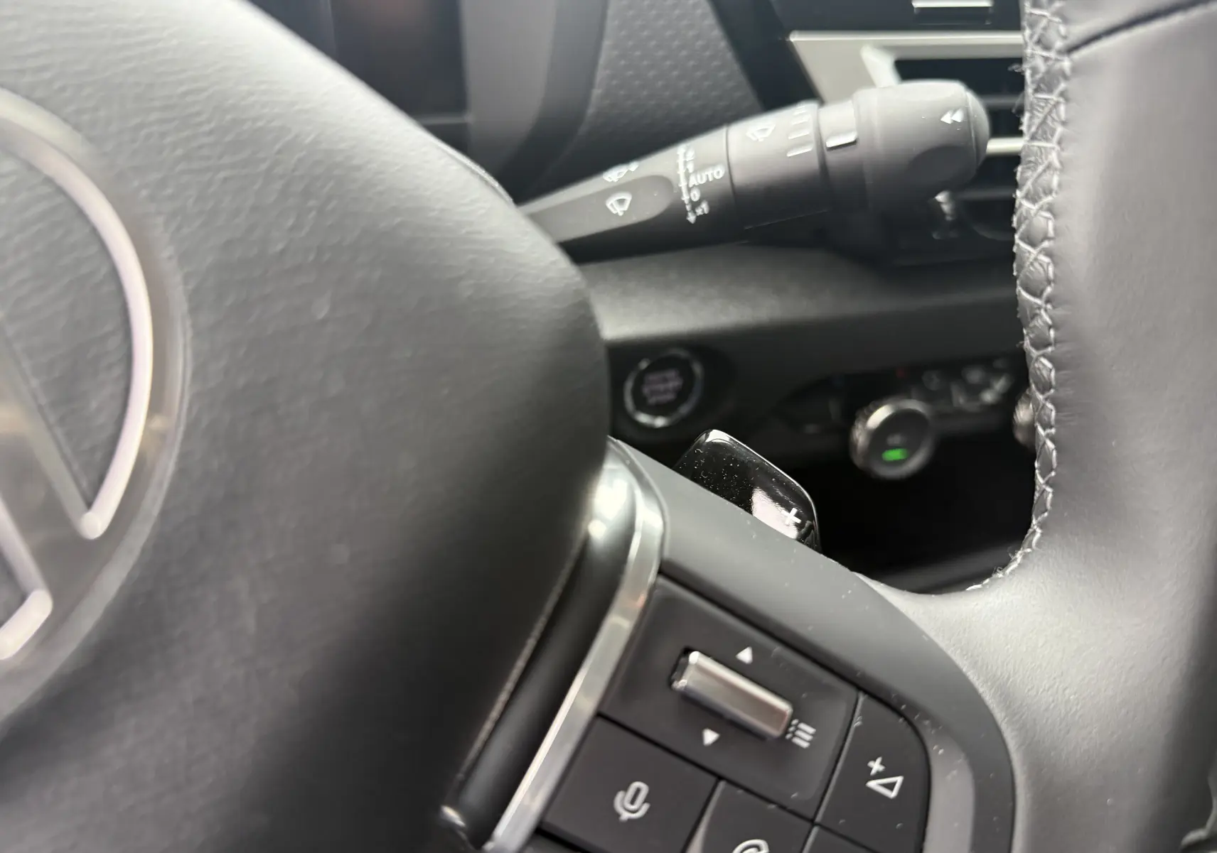 Gros plan sur le volant cuir noir de la Citroën C4 Hybrid 145, avec commandes vocales et régulateur au volant.