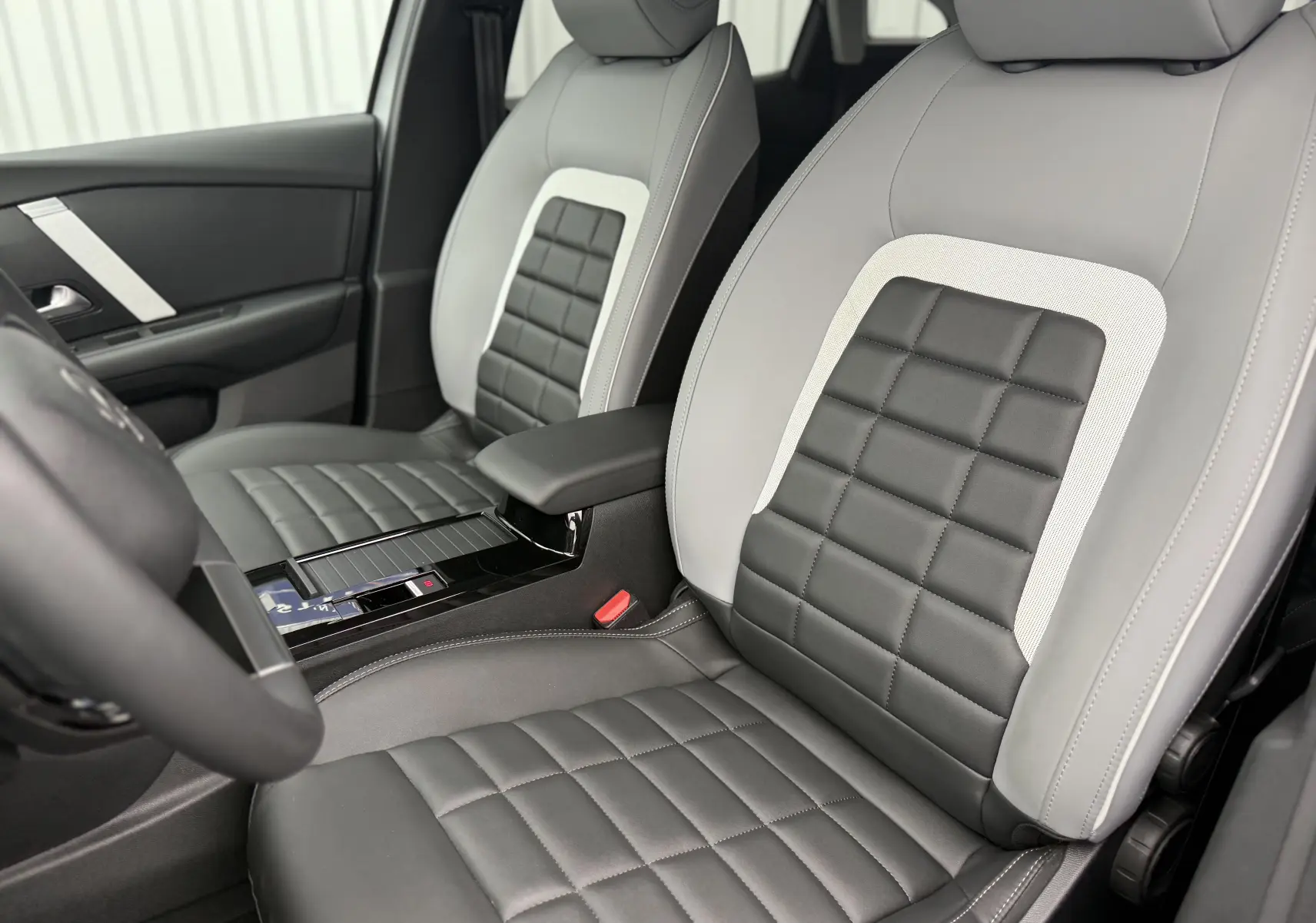 Intérieur de la Citroën C4 Hybrid 145 e-DCS6 Max 2025, vue sur les sièges avant en cuir gris et blanc Okenite.