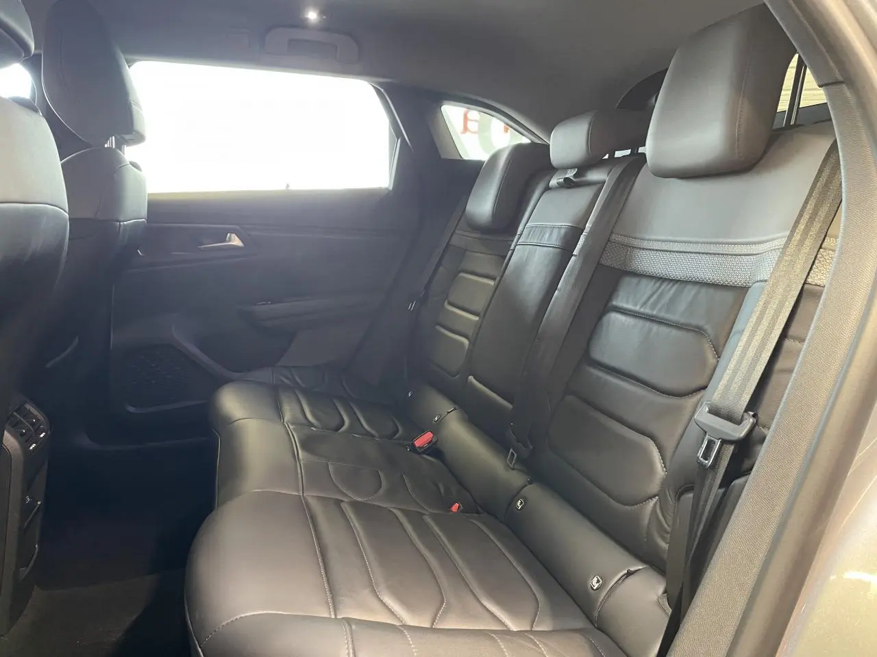 Vue intérieure montrant les sièges arrière en cuir noir du Citroën C5 X 2024, côté droit, avec ceinture de sécurité visible.