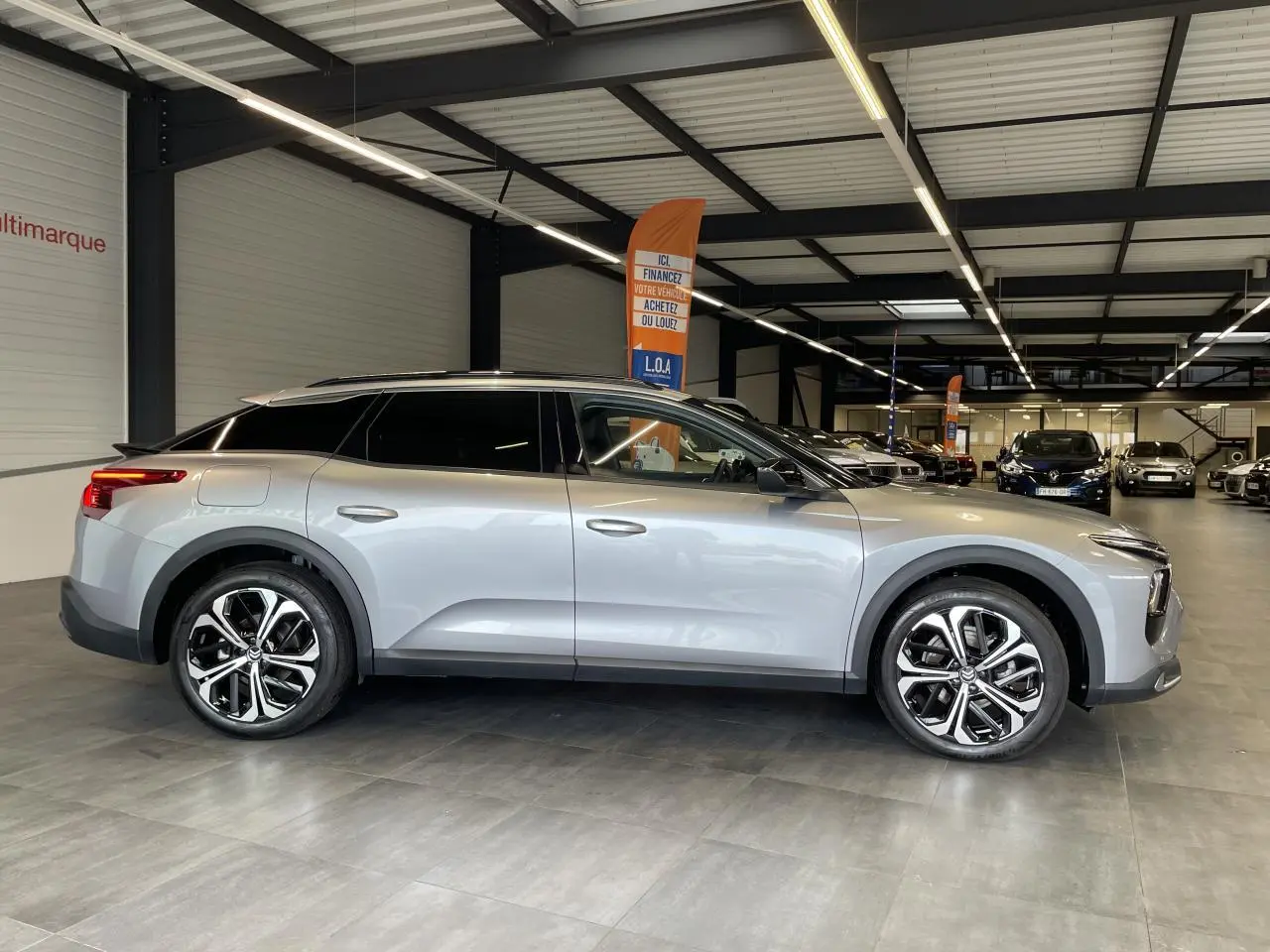 Vue de profil côté gauche du Citroën C5 X 2024 gris foncé, avec ses jantes alliage distinctives en concession.