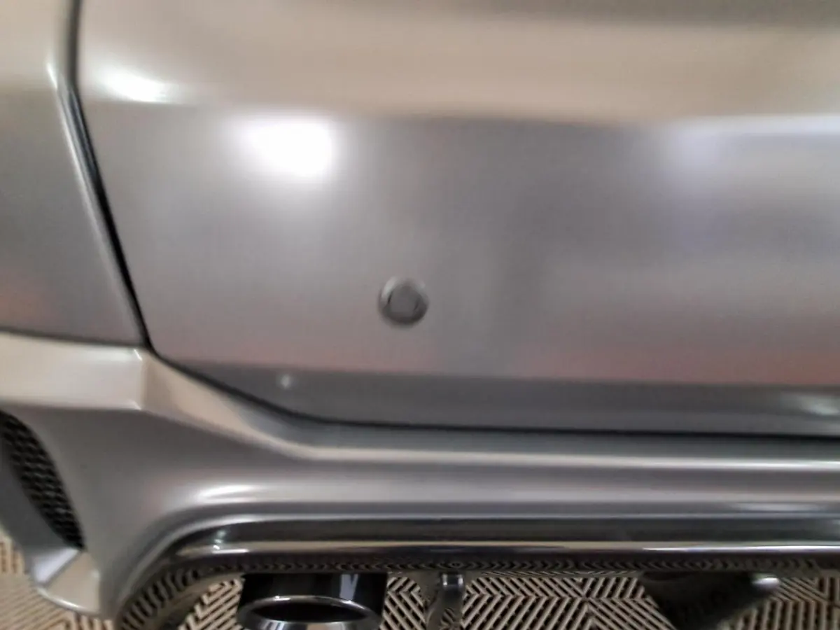 Gros plan sur le pare-chocs arrière gris clair de l'AIXAM AMBITION 2024 avec capteur de recul intégré.